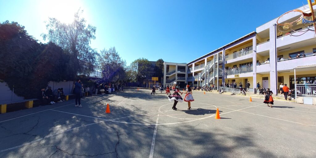 Estudiantes bailando cueca en el patio del colegio durante la celebración de Fiestas Patrias