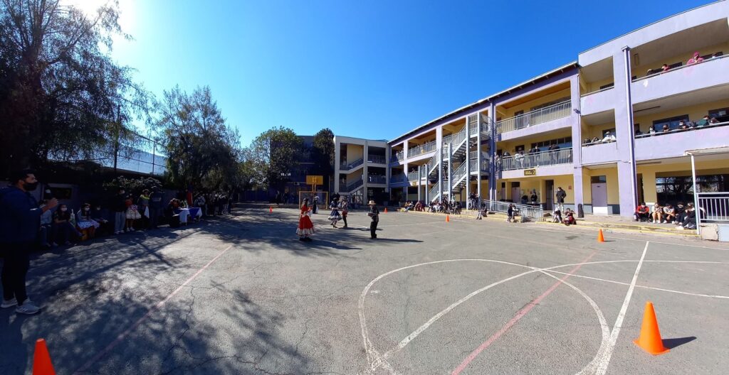 Patio central del Colegio Novo Mundo con el edificio de tres pisos al fondo y estudiantes en los pasillos