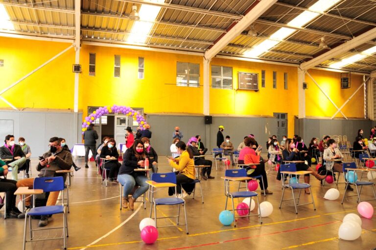 Mesas con proyectos de estudiantes en el gimnasio techado del colegio